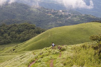 Trekkers on the trail climbing to Shirui Kashong through hill grassland