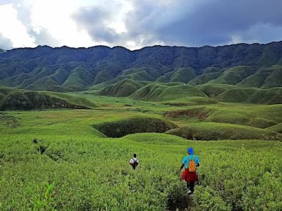 Trekkers descending a ridge into the Dzukou Valley