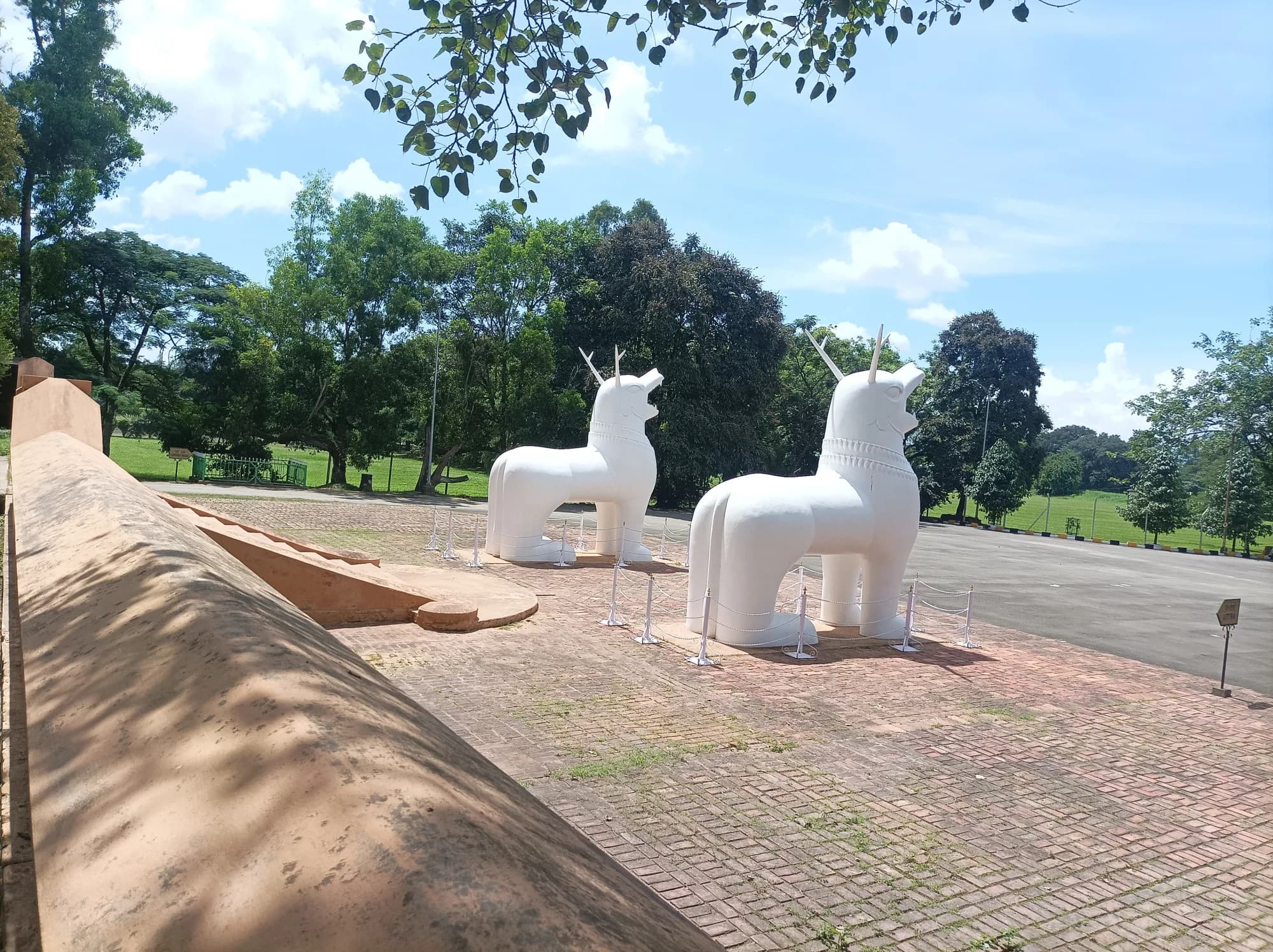 The white kanglasha (dragon-lion guardians) standing on the brick forecourt inside Kangla Fort, Imphal.