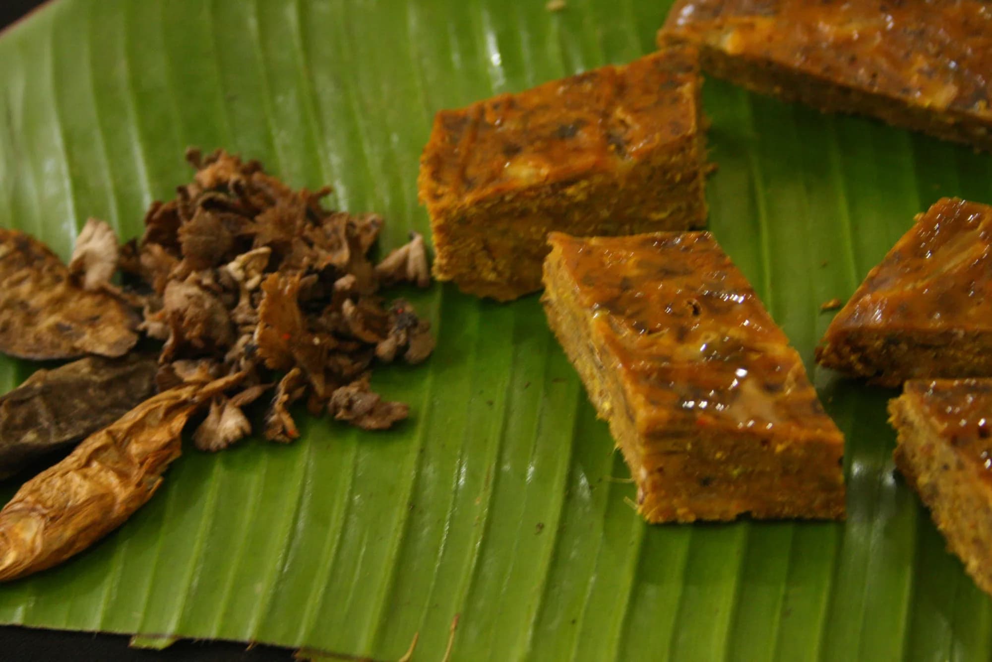 Meitei food served on a banana leaf (fried cakes and dried fish) at the end of a home cooking class