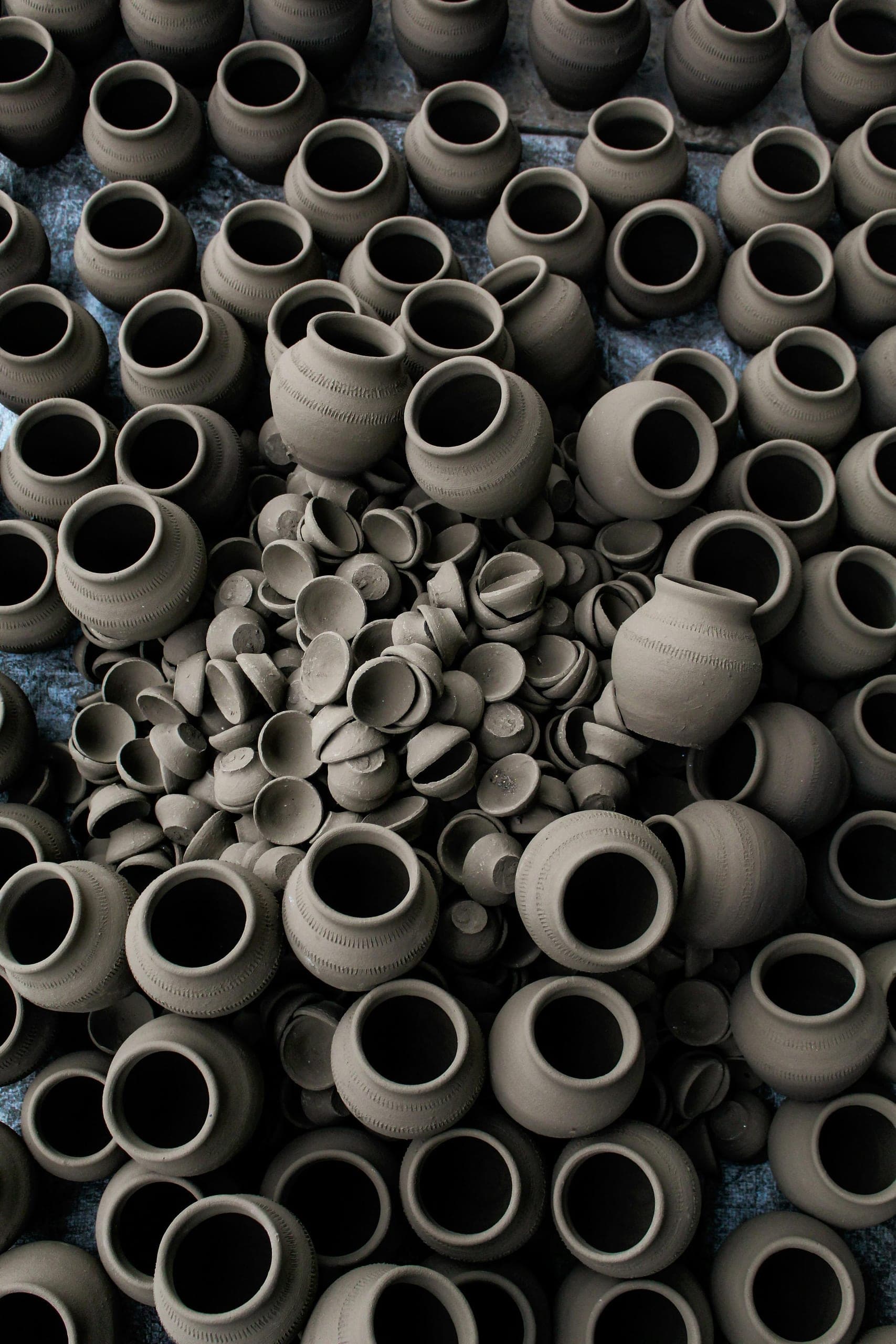 Hands shaping black clay in the Andro pottery workshop